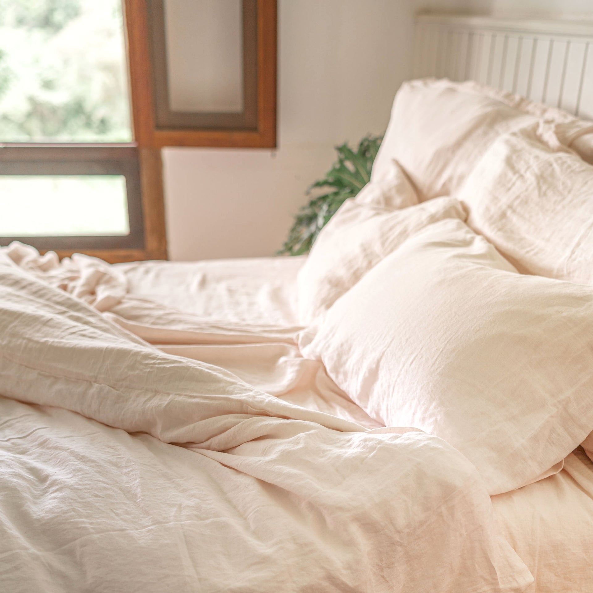 Cozy bed with blush linen bedding 