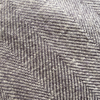 Linen herringbone throw in soft gray tones, showcasing a textured pattern with diagonal lines and subtle variations.